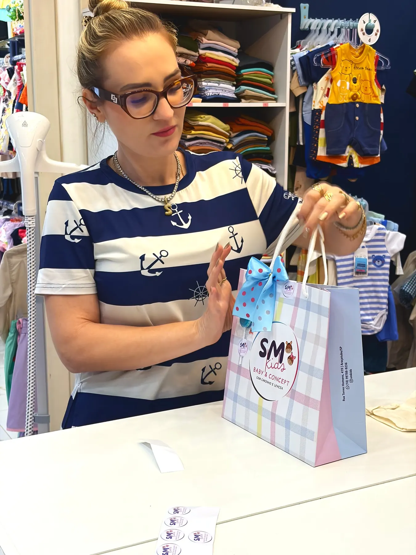 Interior da SM Kids em Araçatuba, com as araras e prateleiras de roupa infantil ao fundo
