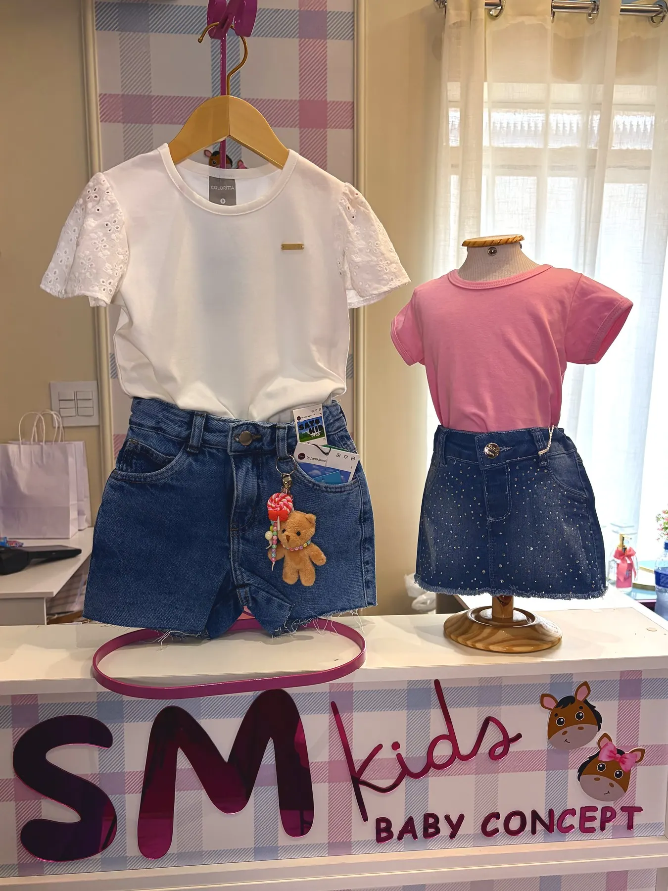Moda juvenil na vitrine da SM Kids: camiseta branca, short e saia jeans